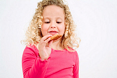 Little girl eating cookie.